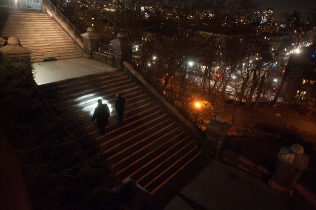 Police officers use a flashlight in Morningside Park after sundown